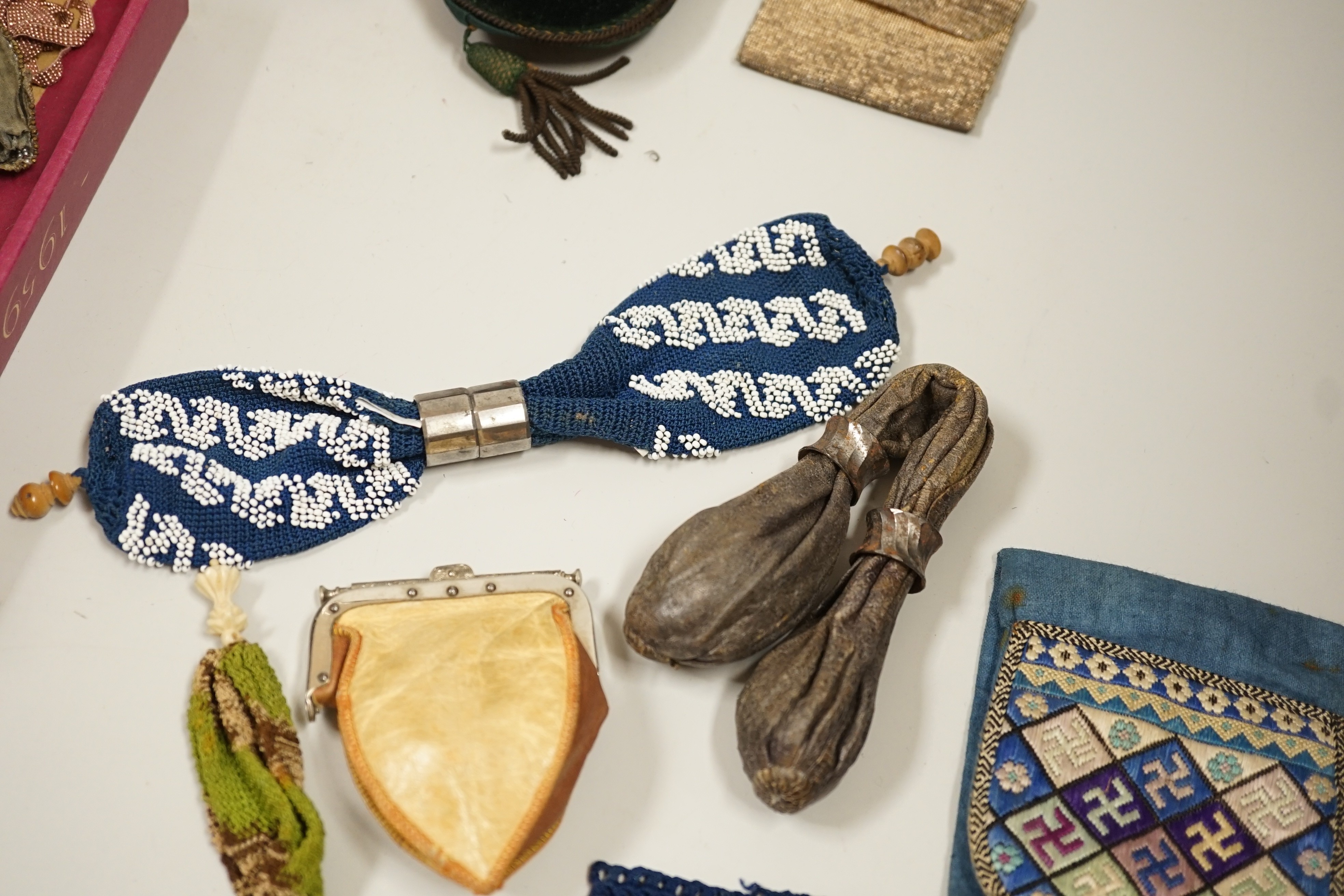 A velvet and metal embroidered reticule possibly 18th century, together with a collection of beaded embroidered knitted and leather purses, bags misers purses and a feather coin purse(14)